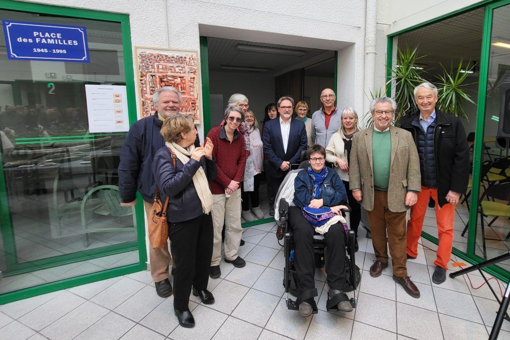 des personnes debout et regroupée, une personne en fauteuil,