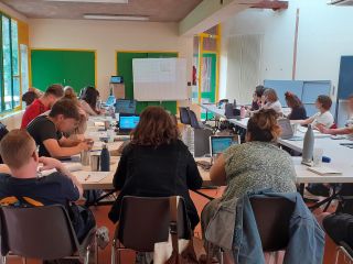 Des personnes assises dans une salle, qui suivent la formation