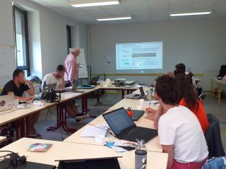 Une salle de formation avec des apprenants qui regardent une présentation