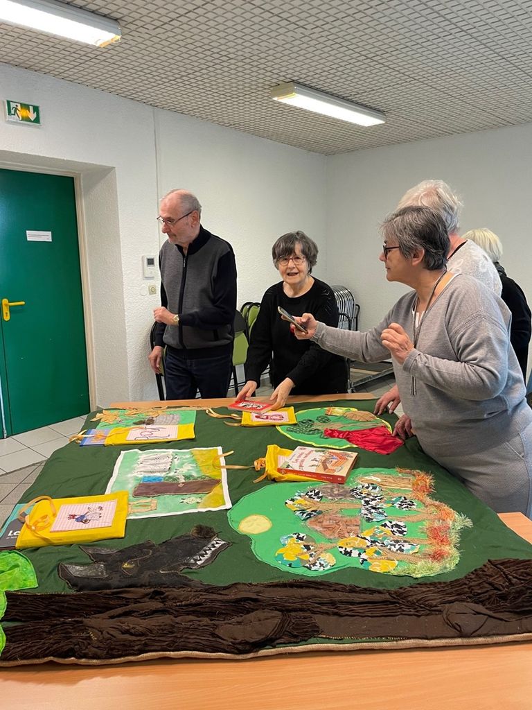 des personnes debout autour d'une table qui regardent un tapis lecture.
